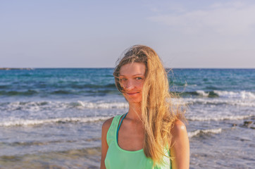 A woman with her hair loose in the wind on the background of the sea
