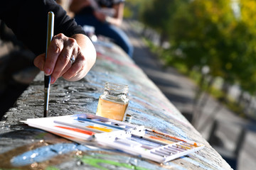Obraz premium Hands Creation picture abstract of watercolor painting with brush in Art subject outside classroom in France