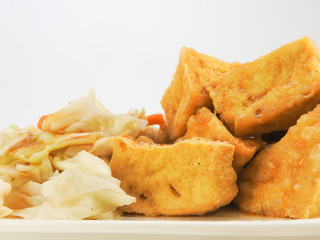 Close up of fried stinky tofu with pickle vegetable, sauce isolated on white background. Traditional Snack at night market. Oriental,Asia,Taiwan food concept.With copy space.