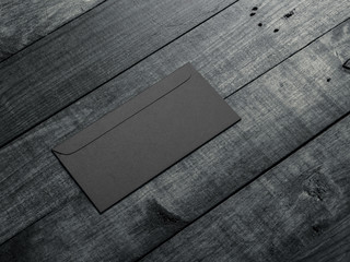 Black envelope mockup on wooden table