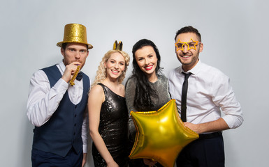 celebration, fun and holidays concept - happy friends posing with golden party props