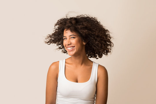 Fototapeta African-american woman fooling with her curly hair
