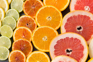 food and healthy eating concept - close up of grapefruit, orange, lemon and lime slices