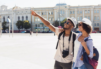 African-american couple of tourists sightseeing in city