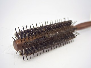 A close up shot on the used dirty comb with hain on the isolated white bakground
