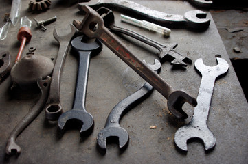 Vintage metal wrenches and tools on metal workbench 
