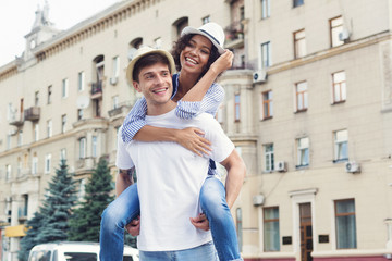 Diverse couple having fun and enjoying piggyback riding