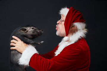 Studio isolated portrait of happy senior Santa Claus with natural grey beard in eyeglasses looking...