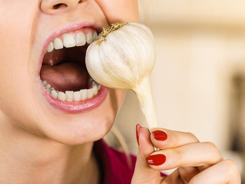 Crazy girl eating garlic vegetable