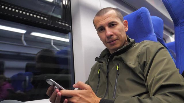 traveler unknown middle-aged man smartphone in the subway writes sms to social media messenger. man in railway train. man traveler in train concept lifestyle travel