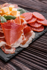Cold smoked meat plate on a rustic wooden background