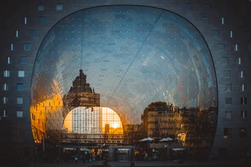 Fototapeten Reflexion des Stadtbildes in Rotterdam an der Fassade der Markthalle (Markthal) während der goldenen Stunde © Ivan Yohan