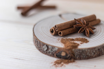 Cinnamon sticks, cinnamon powder, star anise closeup on wood