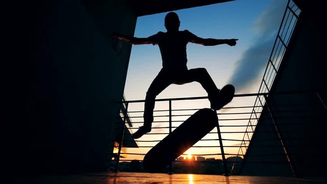 Skateboarder jumping on a sunset background, slow motion.