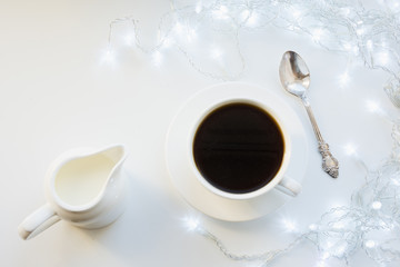 Cup of black coffee on winter white table. Xmas holiday time. Top view.