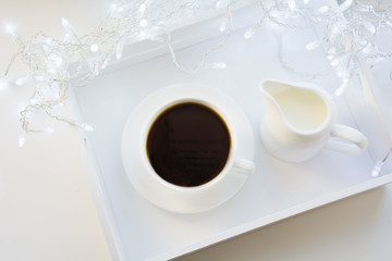 Cup of black coffee on winter white table. Xmas holiday time. Top view.