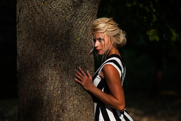 beautiful blonde woman in the autumn forest at sunset