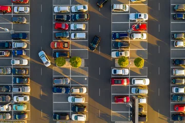 Fotobehang Top down view from drone on mall parking with many cars. © cegli