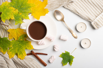 Autumn composition. Hot chocolate, warm wool sweater and autumn leaves, marshmallows. flat lay, top view.