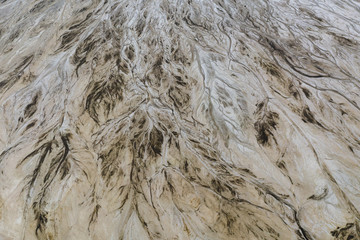 Top down view on abstract patterns and shapes of mineral waste rivers from power plant.