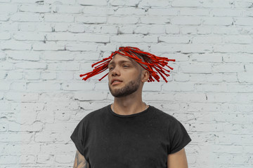 Young attractive man with red dreadlocks shaking his hair.