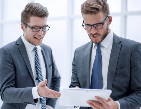 Two Colleagues Looking At The Digital Tablet Screen