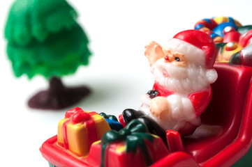 closeup of santa claus on miniature toy train on white background