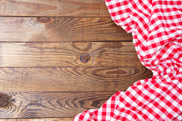 Brown old vintage wooden table with framed red checkered tablecloth.Thanksgiving day and Cristmas table concept. Top view and copy space. Selective focus