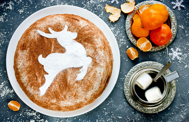 Christmas tiramisu cake, delicious and beautiful cake for winter holidays from biscuit, mascarpone cream and cocoa, decorated with powdered sugar reindeer