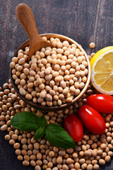 Composition with bowl of soya beans on wooden table