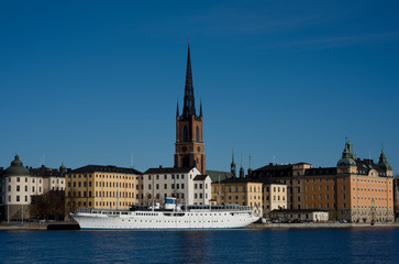 Stockholm water front with landmarks, boats an autumn day with blu sky and sea, orange and red leafs.