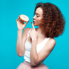 Beautiful young cheerful girl with donut in hand