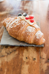 Croissant filled with mascarpone and garnished with cranberries and currants