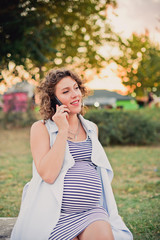 Pregnant woman talking on the phone outdoors