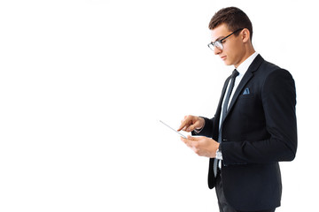 Business man, in a suit and glasses, working on a digital tablet, standing on a white background