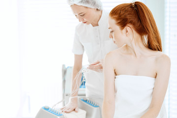 Facial massage at beauty salon. Electronic stimulation woman s muscles with microcurrent therapy....