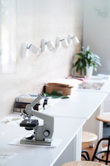 Microscope on the table with a books in the classroom 