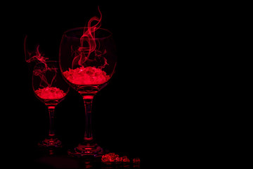 Glowing red drink in wine glasses with red smoke