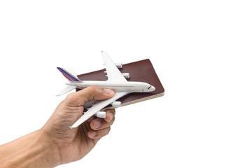 Hand holding a model plane and passport