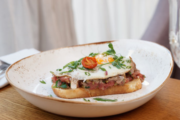 Sandwich with beef tartar and fried egg