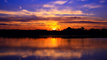 Fototapeta na wymiar Perspective d'un levé de soleil orange sur l'eau