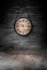 Antique clock on the old, brick wall, wooden floor, smoke, fog. Dark gloomy background of empty room.