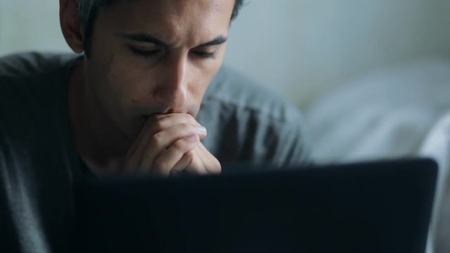 anxious man looking at laptop display