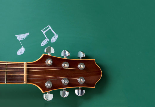 music school concept , guitar  and notes on  blackboard 