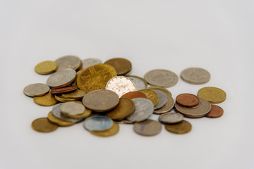 Studio photo of scattered cash coins on white background.