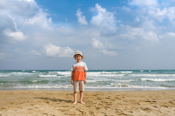 little boy on the beach playing with sand