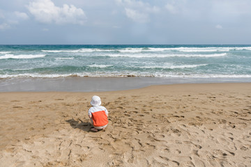 little boy on the beach playing with sand