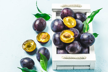Ripe plums in a box. Selective focus, space for text.