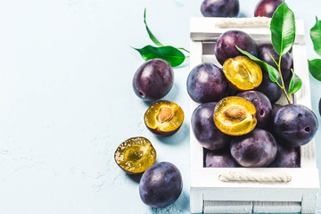 Ripe plums in a box. Selective focus, space for text.