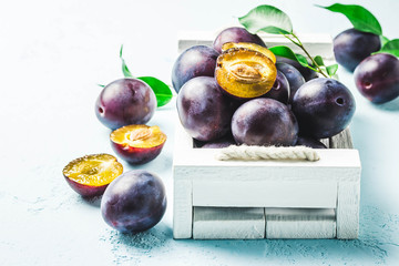 Ripe plums in a box. Selective focus, space for text.